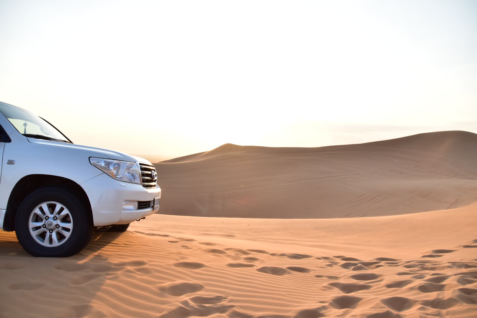 Four-wheel drive vehicle on the crest of a desert dune